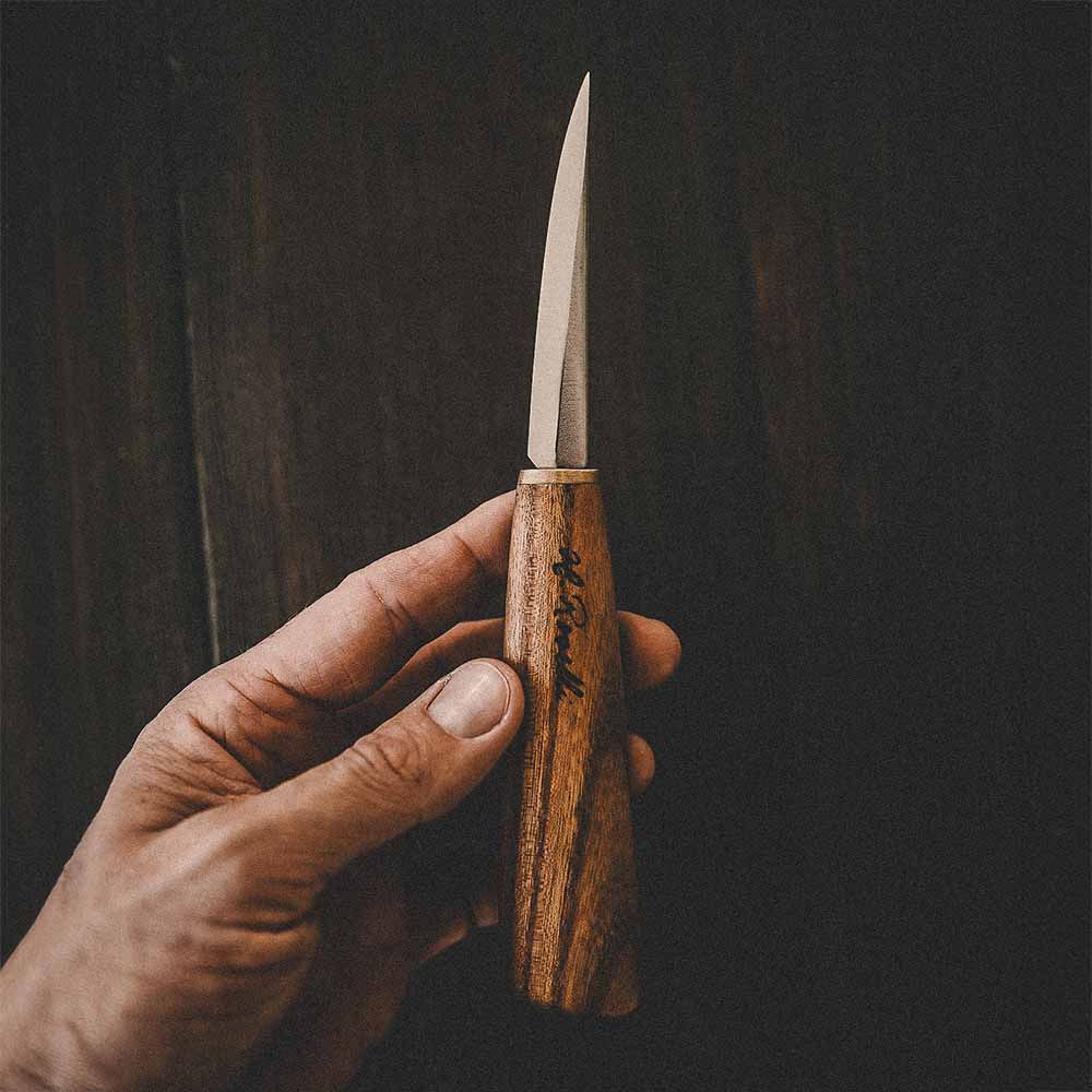 Roselli's handmade Finnish Carving knife with a handle made from red elm and a blade from carbon steel with a scandi grind zero feature. Comes with a handmade leather sheath. 